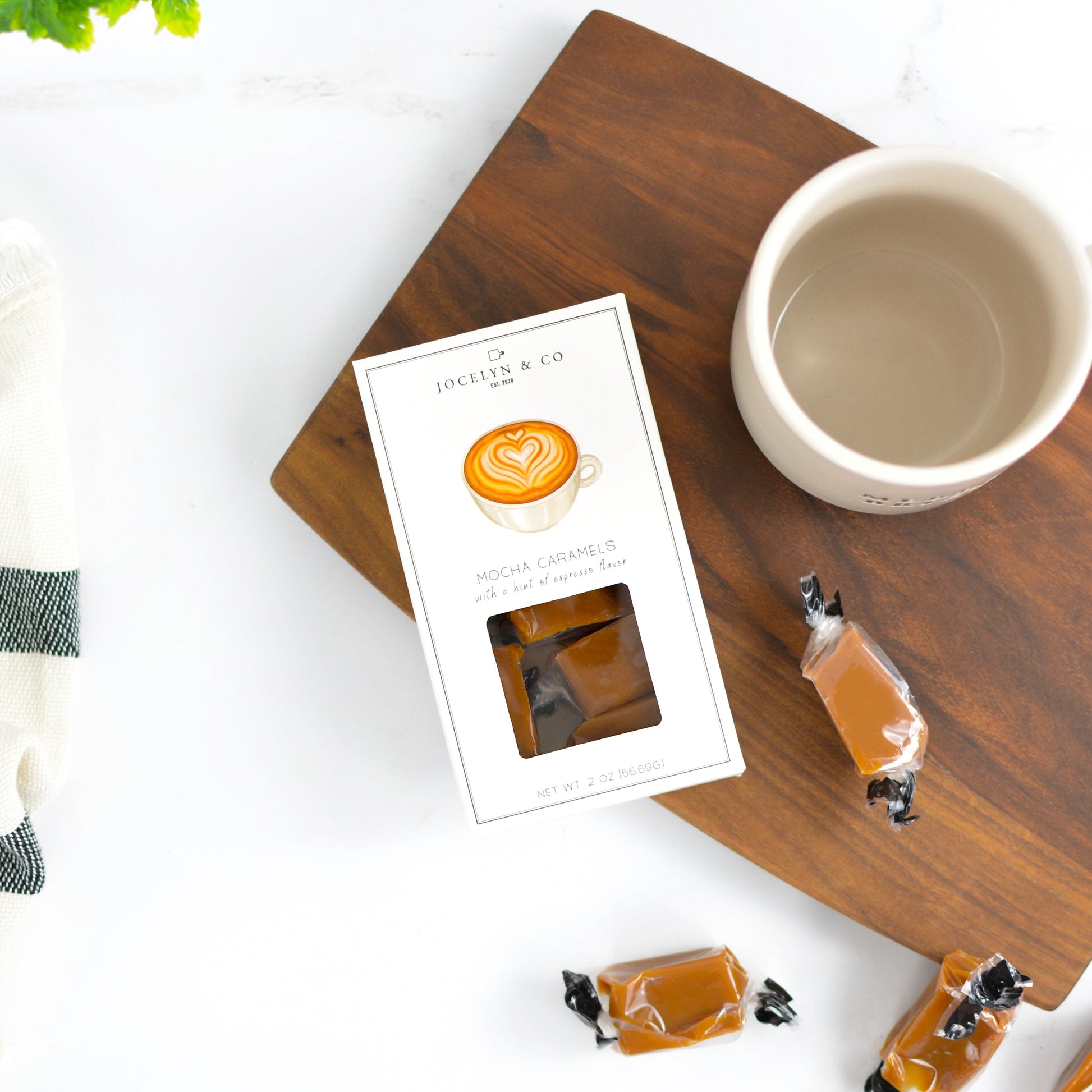 Coffeepods on a wooden tray with a coffee cup and card on a white background